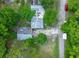 Birds eye of the property with its layout in its wooded surroundings, and its proximity to the road at 10854 Telford St, New Port Richey, FL 34654