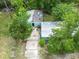 Aerial view of the house showing roof damage and tree coverage, highlighting property's potential at 10854 Telford St, New Port Richey, FL 34654