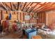A basement shows wood beams, a bicycle, equipment, a ladder, and trash at 10854 Telford St, New Port Richey, FL 34654