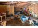 A basement shows wood beams, equipment, chairs, a table, a bicycle, and trash at 10854 Telford St, New Port Richey, FL 34654