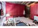 A bedroom shows a red wall, a bed, side table with lamp, and a hanging guitar on the wall at 10854 Telford St, New Port Richey, FL 34654
