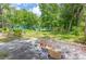 Exterior of a green house on a large lot with debris and overgrown landscaping at 10854 Telford St, New Port Richey, FL 34654