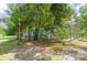 Exterior of a green house on a large lot with overgrown landscaping and a screened porch at 10854 Telford St, New Port Richey, FL 34654