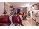 A cluttered living room featuring a red couch, tile flooring, and minimal lighting at 10854 Telford St, New Port Richey, FL 34654