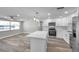 Modern kitchen featuring stainless steel appliances, white cabinetry, an island, and stylish pendant lighting at 10900 Queens Rd, Port Richey, FL 34668