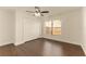 This bedroom includes wood-look floors, a ceiling fan, a window letting in lots of natural light, and a double door closet at 10930 Banyan Wood Way, Riverview, FL 33579