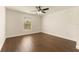 This bedroom includes wood-look floors and a window overlooking a wooded area at 10930 Banyan Wood Way, Riverview, FL 33579