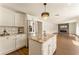Kitchen showcases granite countertops, stainless steel appliances, white cabinetry, and an island with wood-look flooring at 10930 Banyan Wood Way, Riverview, FL 33579