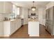 Bright kitchen features white cabinets, granite countertops, stainless steel appliances, and an island with a stylish chandelier at 10930 Banyan Wood Way, Riverview, FL 33579
