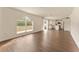 Open-concept living room with hardwood floors, large windows, and bright modern kitchen at 10930 Banyan Wood Way, Riverview, FL 33579