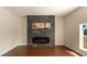 Living room featuring a modern fireplace with gray tiled backdrop and wood-look floors, creating a warm, inviting space at 10930 Banyan Wood Way, Riverview, FL 33579