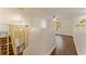 Open loft space features a modern chandelier, wood-look flooring, and a view of the staircase and natural light at 10930 Banyan Wood Way, Riverview, FL 33579