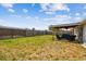 Large backyard with covered patio area, surrounded by a wood fence at 1150 Grand Blvd, Holiday, FL 34690