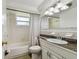 Clean, functional bathroom with tiled walls, updated granite countertop, and shower curtain at 1150 Grand Blvd, Holiday, FL 34690