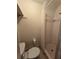 Cozy bathroom featuring a standard toilet, tiled walls, and walk-in shower with curtain at 1150 Grand Blvd, Holiday, FL 34690