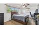 Cozy bedroom featuring a ceiling fan, two windows, and a bed with brown wood frame at 1150 Grand Blvd, Holiday, FL 34690