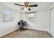 Bright bedroom featuring a ceiling fan, carpeted floors, and two windows at 1150 Grand Blvd, Holiday, FL 34690