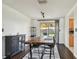 Bright dining room with hardwood floors, rustic table, modern lighting, and sliding glass door to the backyard at 1150 Grand Blvd, Holiday, FL 34690