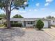 Charming single-story home with large tree, featuring a stone facade garage and well-maintained, zero-scape front yard at 1150 Grand Blvd, Holiday, FL 34690