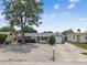 Charming single-story home with large tree, featuring a stone facade garage and well-maintained, zero-scape front yard at 1150 Grand Blvd, Holiday, FL 34690