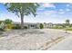 View of the house and driveway, stone accents with mature landscaping, and ample parking at 1150 Grand Blvd, Holiday, FL 34690