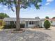 Charming single-story home with mature shade tree, featuring a stone facade garage and zero-scape front yard at 1150 Grand Blvd, Holiday, FL 34690