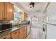 Bright kitchen features a stainless steel sink and wooden cabinetry with lots of natural light at 1150 Grand Blvd, Holiday, FL 34690