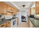 Bright kitchen with wood cabinetry, tile backsplash and flooring, and white appliances at 1150 Grand Blvd, Holiday, FL 34690
