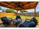 Outdoor patio with cushioned seating under a wood pergola and ceiling fan at 1150 Grand Blvd, Holiday, FL 34690