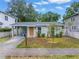 Charming single-story home with well-kept lawn, covered parking, and a welcoming orange front door at 116 W Chelsea St, Tampa, FL 33603