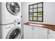 Convenient laundry area with stacked washer and dryer, counter space, and a window at 116 W Chelsea St, Tampa, FL 33603