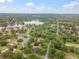 Aerial view of a property highlighting its location surrounded by lush trees and serene lakes at 1204 Ballinger Rd, Lutz, FL 33548