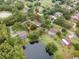 Aerial view showcasing a home near a pond, surrounded by trees and residential properties at 1204 Ballinger Rd, Lutz, FL 33548
