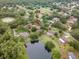 Aerial view of a home with mature trees near a private pond offering a peaceful and private residential setting at 1204 Ballinger Rd, Lutz, FL 33548