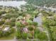 An aerial view highlighting a property with a well-maintained lawn and mature trees, nestled near a scenic pond at 1204 Ballinger Rd, Lutz, FL 33548