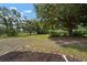 Expansive backyard featuring mature trees, a lush lawn, and ample space for outdoor activities at 1204 Ballinger Rd, Lutz, FL 33548