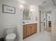 Bathroom featuring a vanity with sink, arched mirror, toilet, decorative lights and neutral flooring at 1204 Ballinger Rd, Lutz, FL 33548