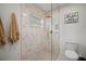 Neutral bathroom with a glass door shower and a sign that says, 