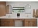 Bright bathroom featuring blond wood cabinets, white countertops and double mirrors at 1204 Ballinger Rd, Lutz, FL 33548