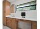 Bathroom with blond wood cabinets, white countertop and rectangular window at 1204 Ballinger Rd, Lutz, FL 33548