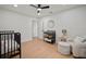 A bright Bedroom featuring a dark metal crib, a comfy chair, and wood floors at 1204 Ballinger Rd, Lutz, FL 33548