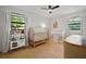 Bright bedroom featuring a crib, play kitchen, tent, natural light and a ceiling fan at 1204 Ballinger Rd, Lutz, FL 33548