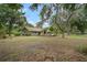 Well-maintained home with a spacious front yard, mature trees, and a manicured lawn at 1204 Ballinger Rd, Lutz, FL 33548