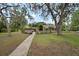 Charming home with mature trees, a well-manicured lawn, and a welcoming walkway at 1204 Ballinger Rd, Lutz, FL 33548