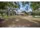 Inviting home exterior with a large front yard, mature trees, and lush landscaping at 1204 Ballinger Rd, Lutz, FL 33548