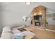 Living room featuring brick fireplace with mounted tv, neutral toned furnishings, and open floorplan at 1204 Ballinger Rd, Lutz, FL 33548