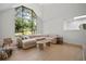 Bright living room features vaulted ceiling, large windows, and modern neutral toned furnishings at 1204 Ballinger Rd, Lutz, FL 33548