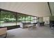 Covered outdoor patio featuring a seating area and dining table overlooking the backyard at 1204 Ballinger Rd, Lutz, FL 33548