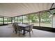 Covered outdoor patio with seating and dining areas overlooking a lush backyard at 1204 Ballinger Rd, Lutz, FL 33548