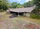 Rear of house with a screened lanai and mature trees surrounding the property at 1204 Ballinger Rd, Lutz, FL 33548